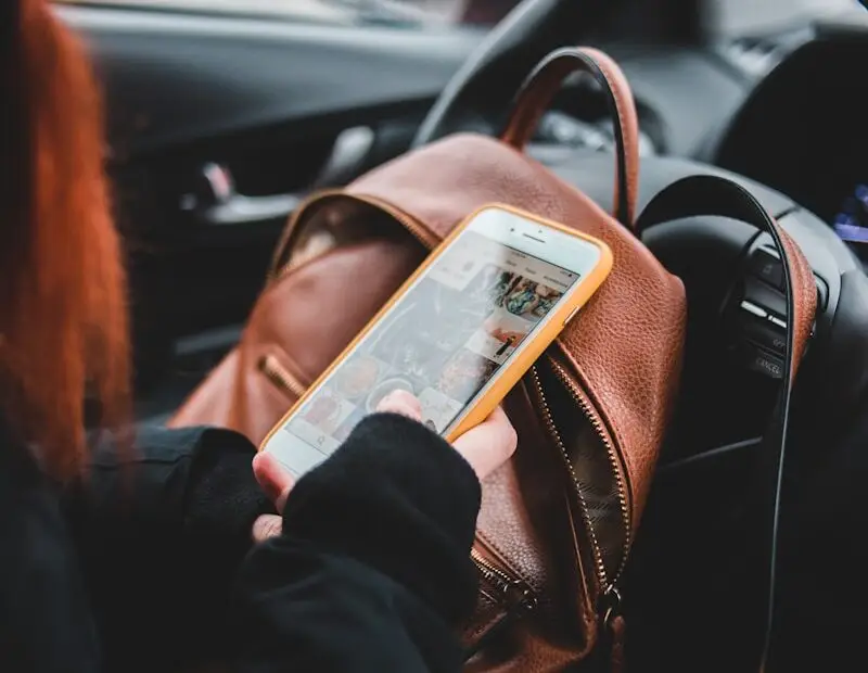 woman in black jacket in a car holding iphone 6